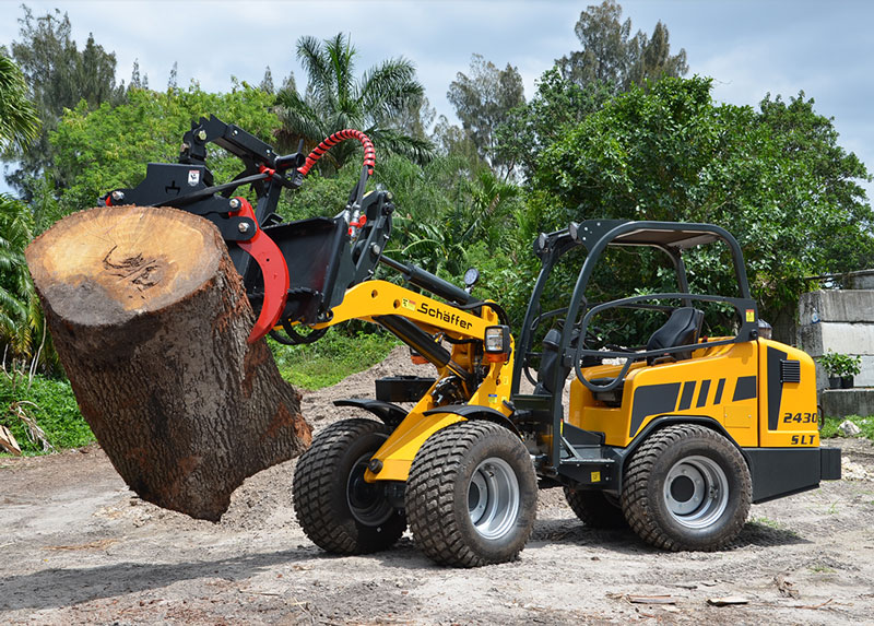 Schaffer 2430 SLT wheel loader lifts thick tree log