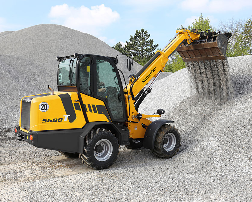 Schaffer 5680 telescopic wheel loader with bucket moving sand